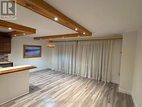Toronto (Don Valley Village) condo for rent - A room with wooden beams on the ceiling and a painting hanging on the wall.