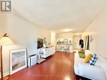 Toronto (Willowdale East) condo for rent - A living room with a white couch and a painting on the wall.