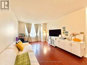 Toronto (Willowdale East) condo for rent - A living room with a white couch and a television on a white cabinet.