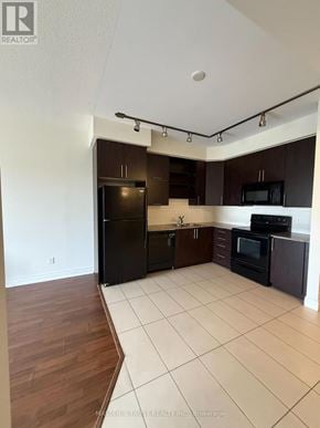 Markham (Unionville) condo for rent - A kitchen with black appliances and brown cabinets.