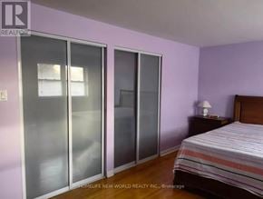 Toronto (Tam O'shanter-Sullivan) apartment for rent - A bedroom with a bed, nightstand, and sliding glass doors.