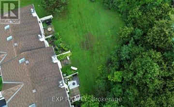 Ottawa townhouse for rent - A bird's eye view of a house with a brown roof and a green lawn.
