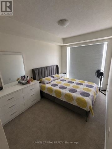Toronto (Malvern) townhouse for rent - A bedroom with a bed, dresser, and mirror.