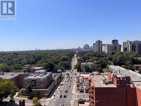 Toronto (High Park North) condo for rent - A city street with cars and buildings.
