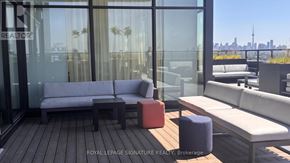 Toronto (High Park North) condo for rent - A modern outdoor seating area with a view of the city skyline.