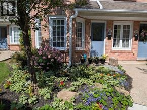 Burlington (Headon) townhouse for rent - A house with a blue door and a garden in front.