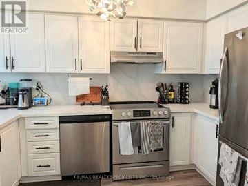 Burlington (Headon) townhouse for rent - A modern kitchen with white cabinets and stainless steel appliances.