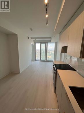 Mississauga (City Centre) condo for rent - A modern kitchen with wooden floors and white walls.