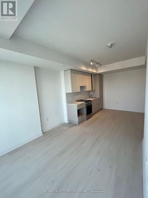 Mississauga (City Centre) condo for rent - A spacious room with a kitchenette and wooden flooring.