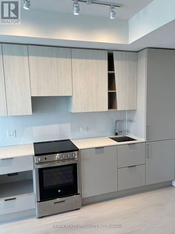 Mississauga (City Centre) condo for rent - A modern kitchen with a stove top oven and a sink.