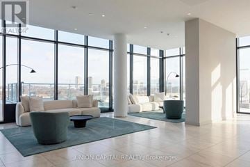 Toronto (Banbury-Don Mills) condo for rent - A spacious living room with a view of the cityscape outside the large windows.