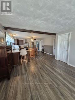 Fort Erie (Ridgeway) apartment for rent - A realtor's image of a room with wooden flooring and a kitchen area.