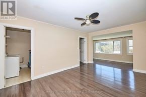 Fort Erie (Central) apartment for rent - A spacious room with a ceiling fan and hardwood flooring.