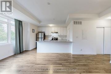 Richmond Hill (Langstaff) townhouse for rent - A spacious kitchen with white cabinets and a wooden floor.