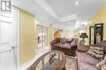 Brampton (Bram East) apartment for rent - A living room with a brown couch and a glass table.