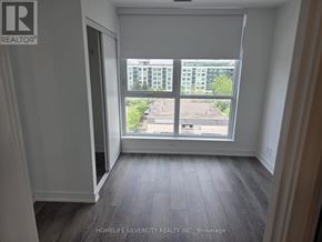 Toronto (Clairlea-Birchmount) condo for rent - A room with a large window overlooking a parking lot.