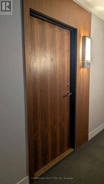 Toronto (Waterfront Communities) condo for rent - A brown door with a black handle and a light on the wall.