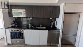 Toronto (Waterfront Communities) condo for rent - A modern kitchen with a stove, oven, and refrigerator.