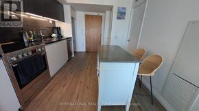 Toronto (Waterfront Communities) condo for rent - A modern kitchen with a wooden floor and a stove top oven.