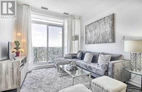 Toronto (Yonge-St. Clair) condo for rent - A living room with a grey couch, a glass table, and a large window with a view of the balcony.