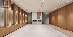 Toronto (Regent Park) condo for rent - A long hallway with wood paneling and a stone wall.