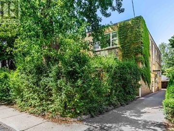 Toronto (Yonge-St. Clair) triplex for rent - A building with a green plant on the side.