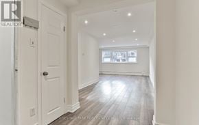 Toronto (Yonge-St. Clair) triplex for rent - A spacious room with a door and a window.