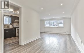Toronto (Yonge-St. Clair) triplex for rent - A spacious room with wood flooring and a large window.