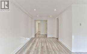 Toronto (Yonge-St. Clair) triplex for rent - A hallway with wood flooring and white walls.