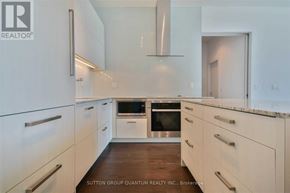 Toronto (Lawrence Park South) condo for rent - A modern kitchen with white cabinets and a wooden floor.