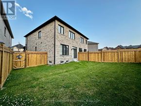 Whitby apartment for rent - A house with a wooden fence and a green lawn in front.
