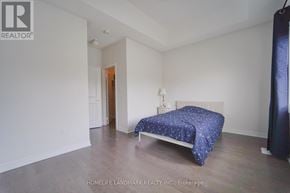 Whitby apartment for rent - A bedroom with a bed and a blue bedspread.