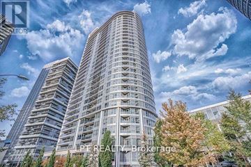 Toronto (Agincourt South-Malvern West) condo for rent - A tall building with a curved facade stands in front of a cloudy sky.