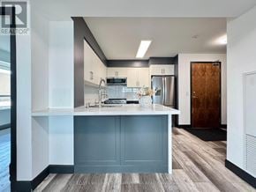 Pickering (Bay Ridges) condo for rent - A modern kitchen with a wooden door and a white countertop.