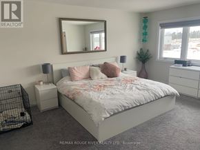 Clarington (Newcastle) apartment for rent - A bedroom with a large bed, a mirror, and a nightstand.