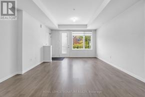 Pickering (Duffin Heights) townhouse for rent - A spacious room with wooden flooring and white walls, with a door leading to a balcony.