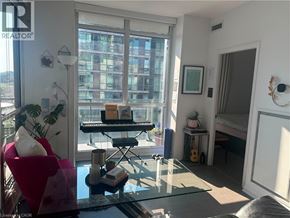 Etobicoke condo for rent - A living room with a red chair, a glass table, and a guitar.