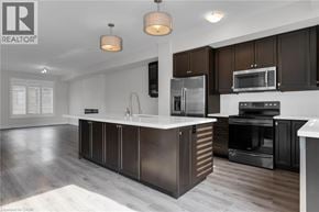 Grimsby townhouse for rent - A modern kitchen with dark brown cabinets and stainless steel appliances.