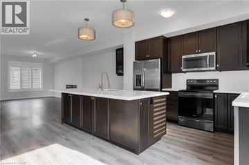 Grimsby townhouse for rent - A modern kitchen with dark brown cabinets and stainless steel appliances.