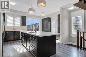 Grimsby townhouse for rent - A modern kitchen with black cabinets and a white countertop.