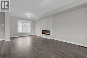 Grimsby townhouse for rent - A spacious living room with a fireplace and wood flooring.