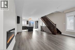 Grimsby townhouse for rent - A spacious living room with a fireplace and a staircase.