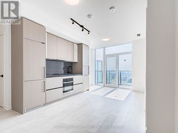 Toronto (Dovercourt-Wallace Emerson-Junction) condo for rent - A modern kitchen with wooden cabinets and a large window.