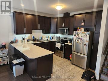 London North (North E) townhouse for rent - A kitchen with a refrigerator, stove, and microwave.