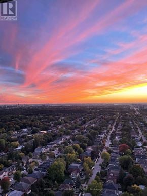 Toronto (Lansing-Westgate) condo for rent - A sunset view of a residential neighborhood with houses and trees.