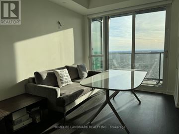 Toronto (Lansing-Westgate) condo for rent - A living room with a grey couch and a glass table.
