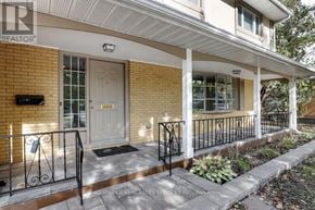 Ottawa apartment for rent - A house with a white porch and a black railing.