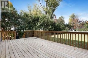 Ottawa apartment for rent - A wooden deck with a railing and trees in the background.