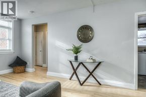 Kitchener apartment for rent - A living room with a grey sofa, a wooden coffee table, and a round mirror on the wall.