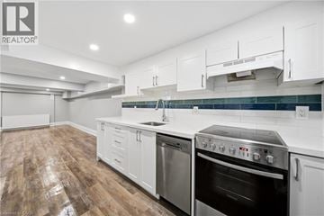 Toronto apartment for rent - A modern kitchen with white cabinets and stainless steel appliances.